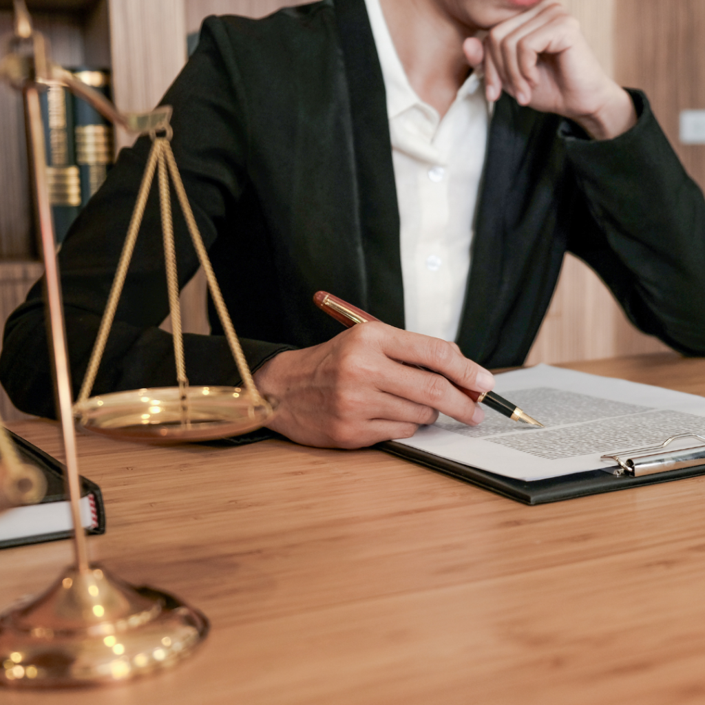 Advogado analisando contrato com balança da justiça à frente, simbolizando a cessão de créditos judiciais.