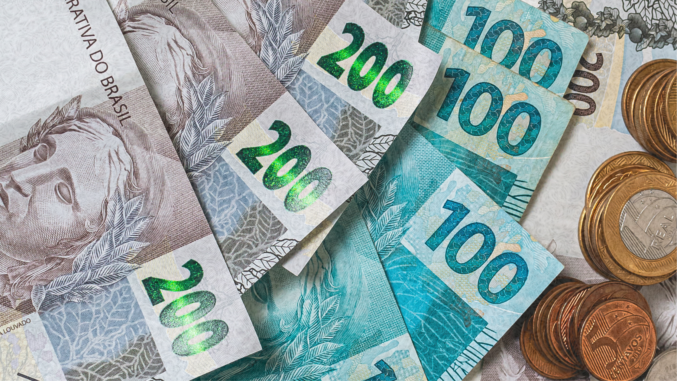 Notas de R$200 e R$100 e moedas representando o teto de 150 salários mínimos no crédito trabalhista