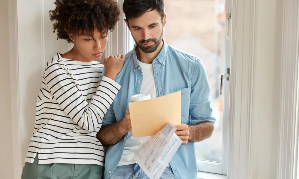 Casal analisando documentos ou contas sobre créditos trabalhistas e empréstimo consignado